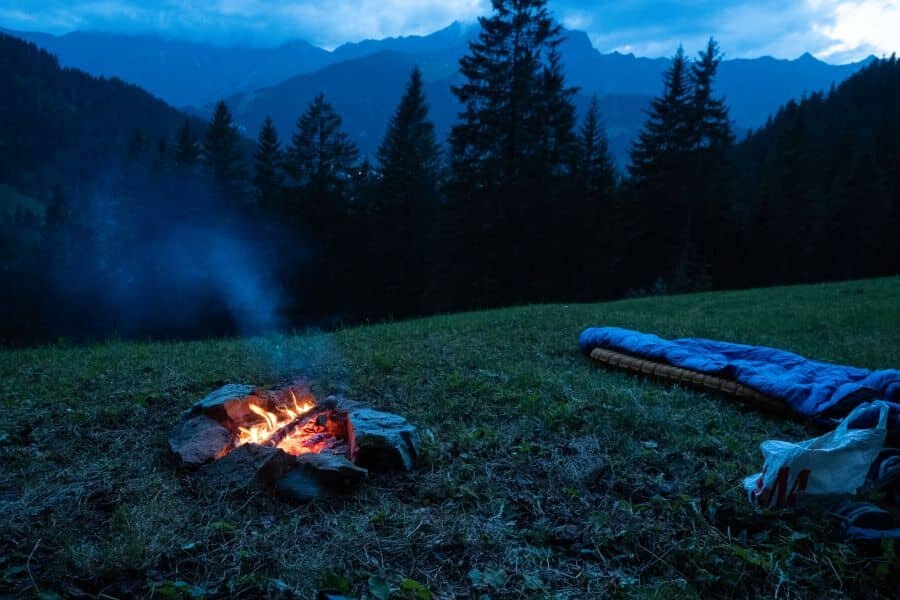 Spanie pod gołym niebem z ogniskiem i widokiem na góry