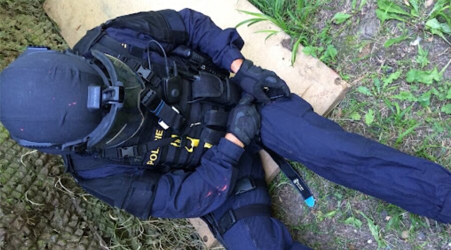 Policjant używa opaski uciskowej