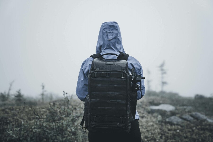 Człowiek w nieprzemakalnej kurtce w zmrożonym krajobrazie. Źródło: https://www.pexels.com/cs-cz/foto/priroda-muz-kmeny-chytry-telefon-5048614/