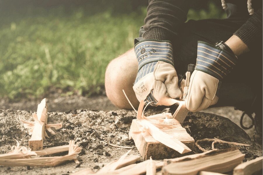 Rozpalanie ognia w rękawiczkach przy użyciu krzesiwa. Źródło: https://www.pexels.com/cs-cz/foto/167708/