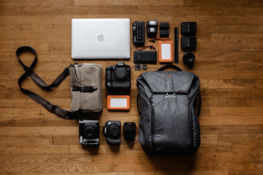 Rozpakowany plecak z aparatami i elektroniką. Źródło: https://www.pexels.com/cs-cz/foto/apple-jablko-chytry-telefon-notebook-3178938/