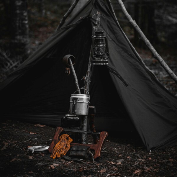 Schronienie bushcraftowe w lesie. Źródło: https://www.pexels.com/cs-cz/foto/les-dobrodruzstvi-kempovani-lampion-14074699/