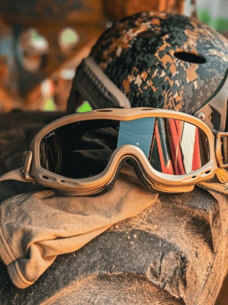 Taktyczne okulary ochronne typu goggles umieszczone na ekwipunku, w tle hełm; przykład zastosowania w trudnym terenie. Foto: Rigad