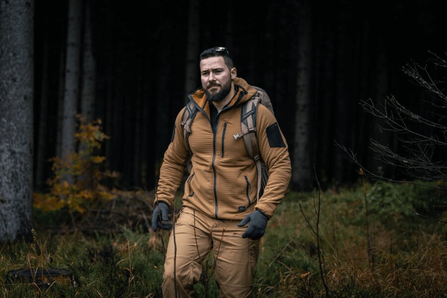 Mężczyzna w bluzie Helikon-Tex Patriot Pro podczas marszu przez las – pokaz lekkiej i wiatroodpornej konstrukcji Stormfleece<sup>®</sup>. Foto: Rigad