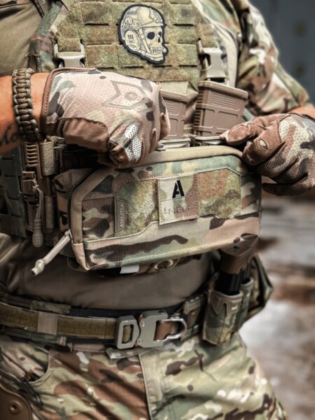 Operator w sprzęcie multicam otwiera Pincer Admin Panel Agilite<sup>®</sup> zamocowany na nosidle płyt K-ZERO SF i manipuluje magazynkami. Foto: Rigad