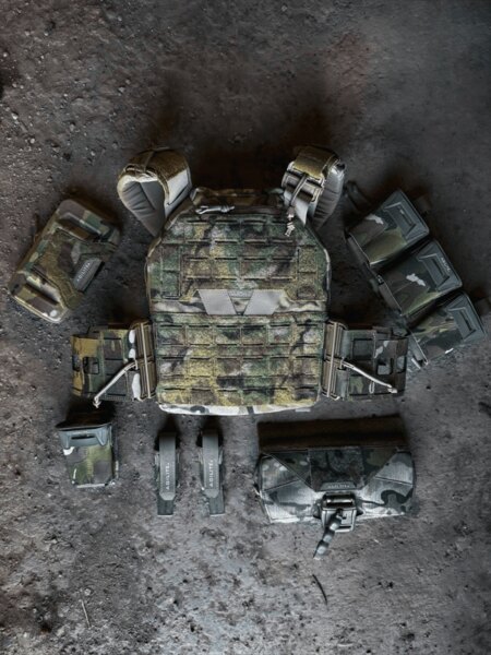Plate carrier K-ZERO™ SF Agilite<sup>®</sup> otoczony akcesoriami, w tym ładownicami Pincer Placard™, pokrowcem BattleShell i tylną kieszenią Rear Hanger. Foto: Rigad