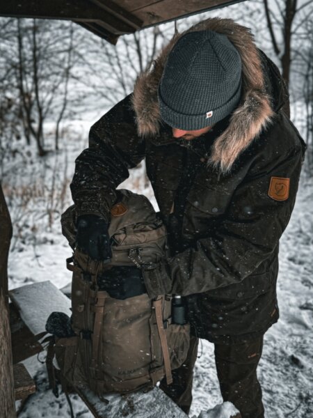 Solidny plecak ekspedycyjny Fjällräven Kajka leżący na śniegu, gotowy na zimową wielodniową wyprawę. Foto: Rigad
