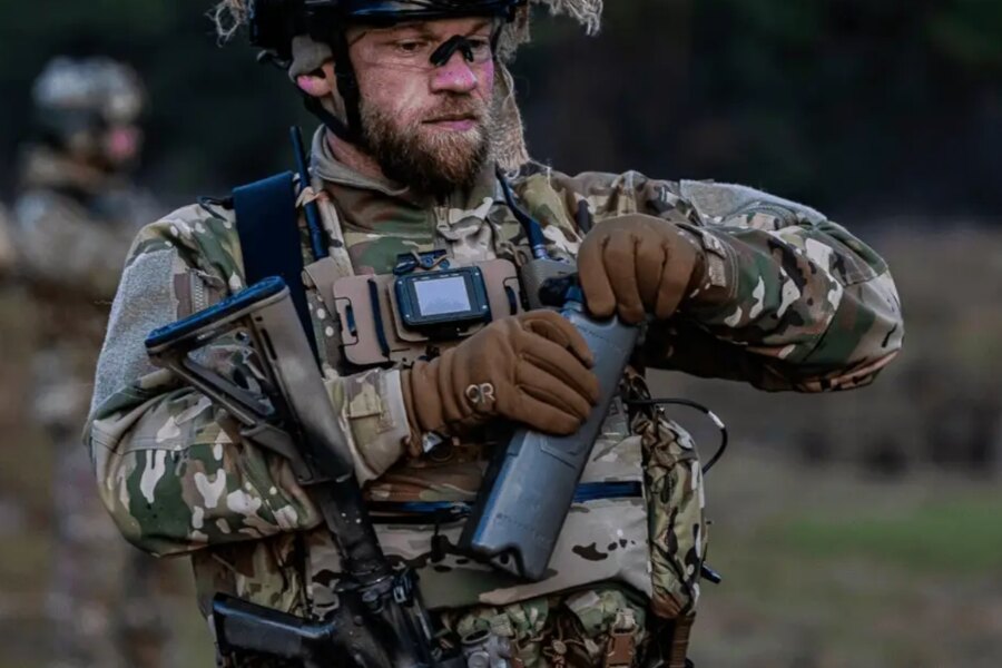 Operator w taktycznym wyposażeniu otwiera system nawadniający Qore Performance ICEPLATE<sup>®</sup> podczas treningu w terenie.