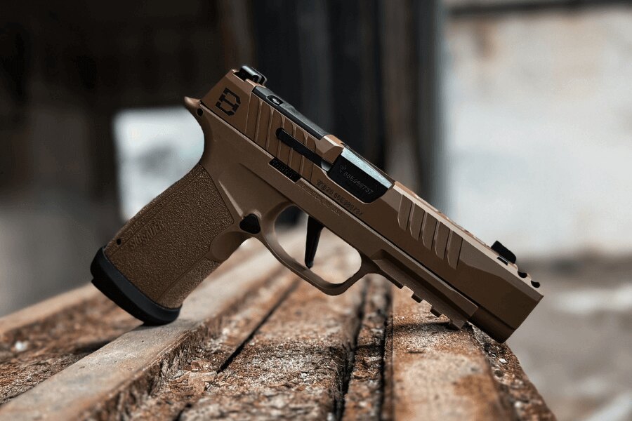 Nowoczesny pistolet samopowtarzalny kalibru 9 mm Luger położony na drewnianym podłożu.