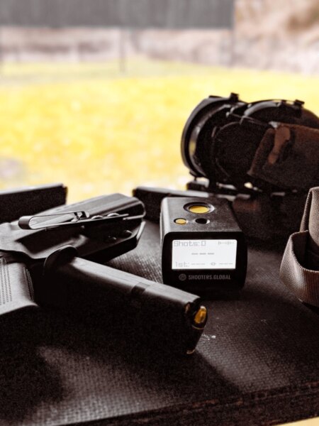 Pistole, magazynki, timer strzelecki Shooters Global i ochronne słuchawki gotowe do treningu.