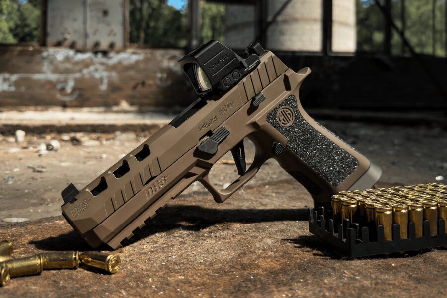 Pistolet SIG Sauer P320 DH3 z kolimatorem Holosun leżący obok amunicji.